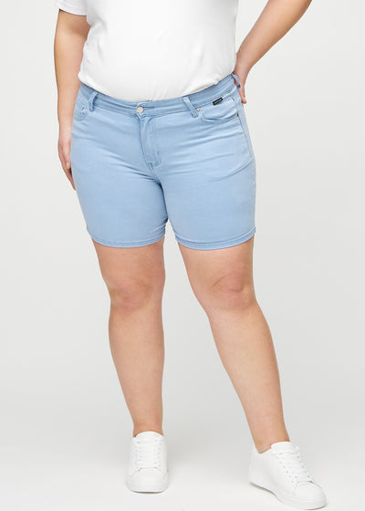 Lyseblå skinny short shorts, modelnavn Skies, som sidder tæt til, og slutter midt på låret på en plus-size model, set forfra.