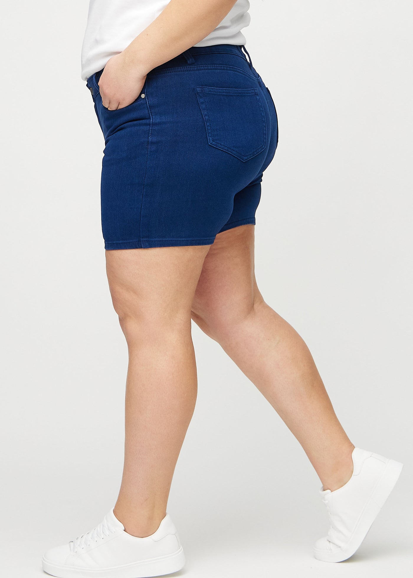 Mørkeblå skinny short shorts set fra siden på en plus-size model.