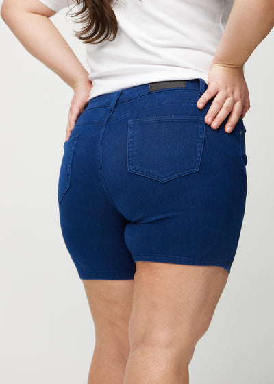 Mørkeblå skinny short shorts set bagfra tæt på en plus-size model for at vise detaljer.