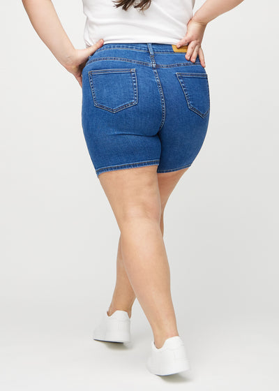 Mørk denim skinny short shorts set bagfra på en plus-size model, så man kan se hele produktet.