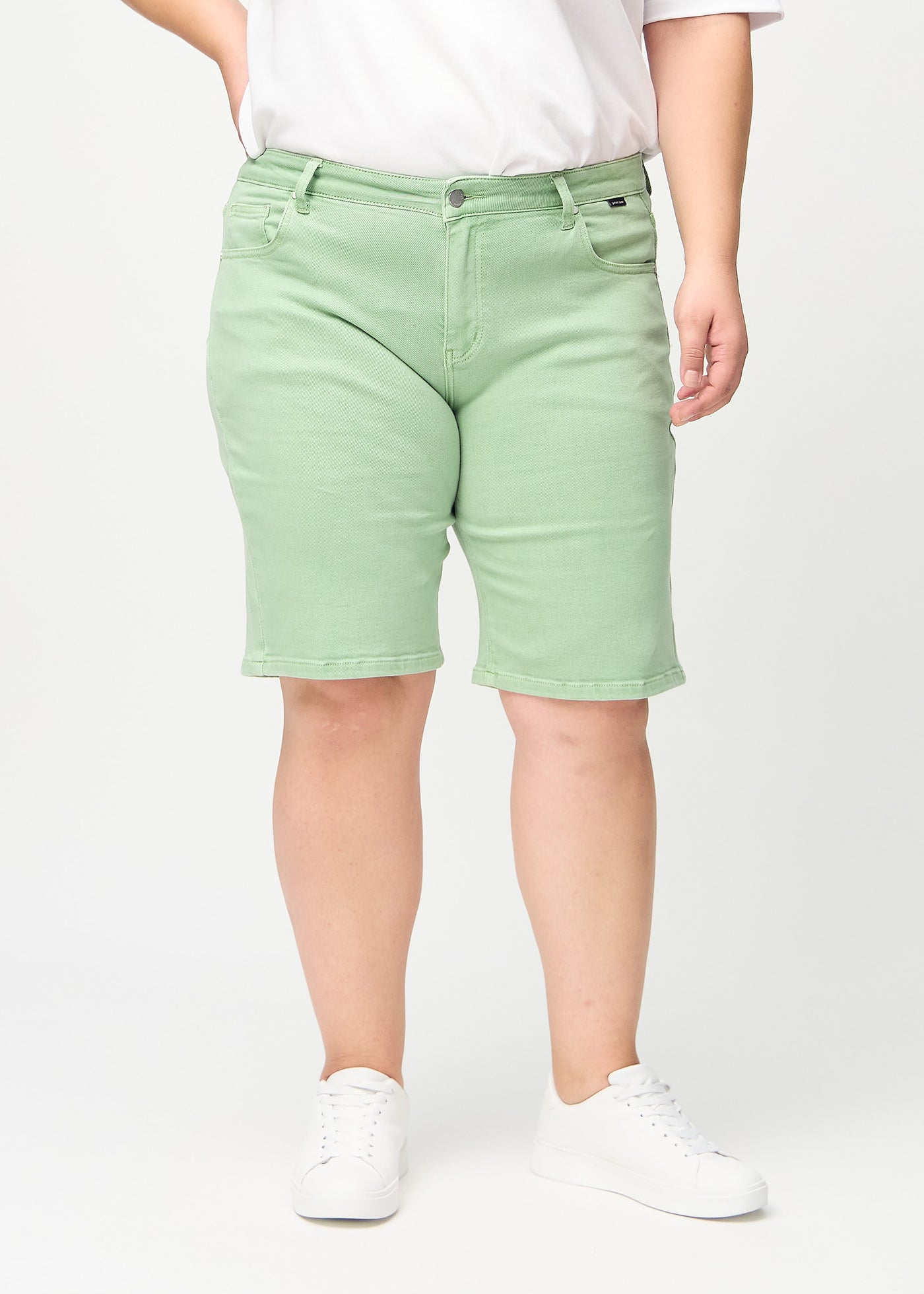 Lysegrønne regular middle shorts, modelnavn Mints, som går lige ned langs benet og slutter lige over knæet på en plus-size model, set forfra.