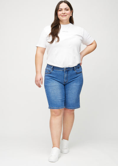 Fuldt billede af en plus-size model i denim regular middle shorts.