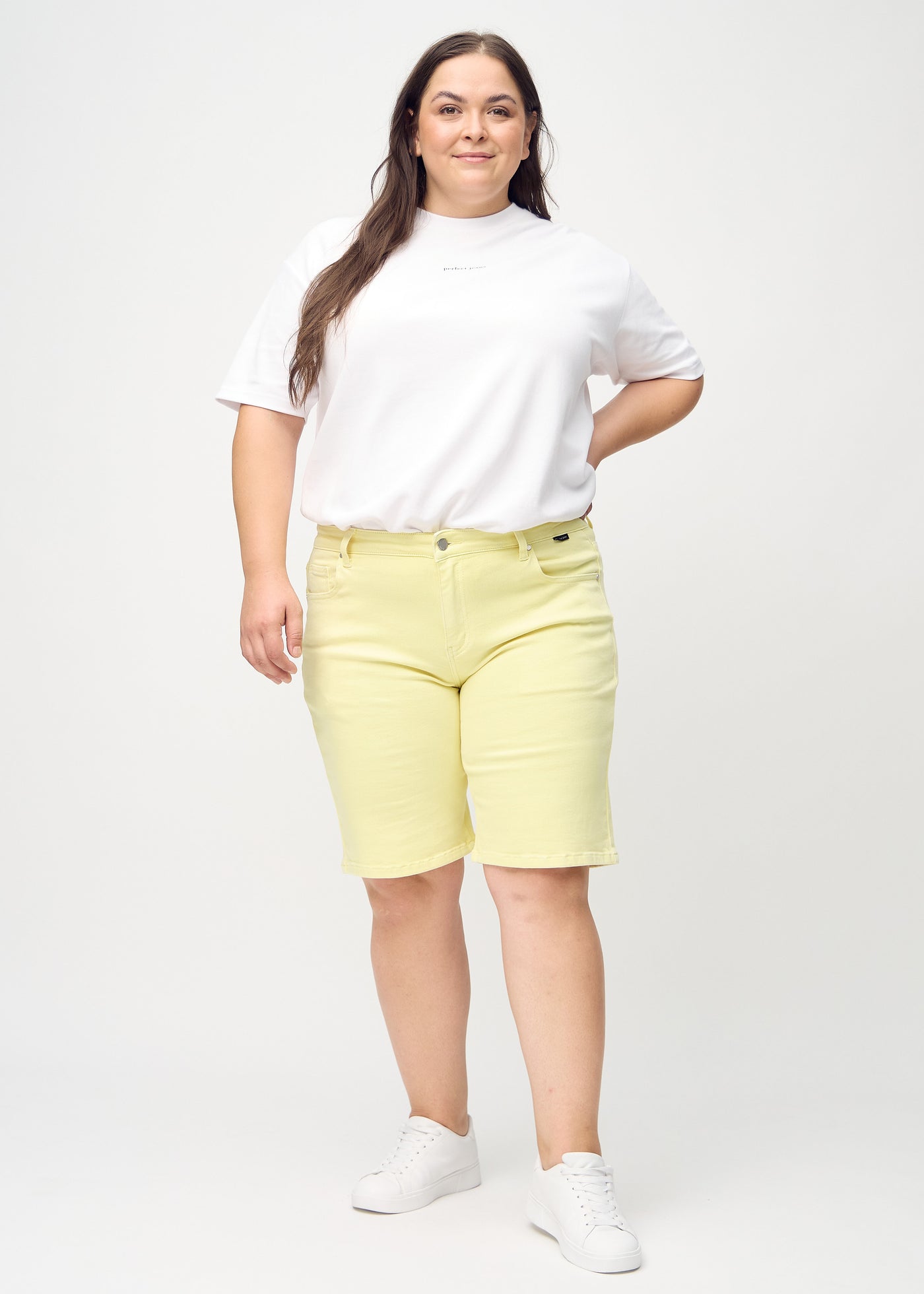 Fuldt billede af en plus-size model i lysegule regular middle shorts.