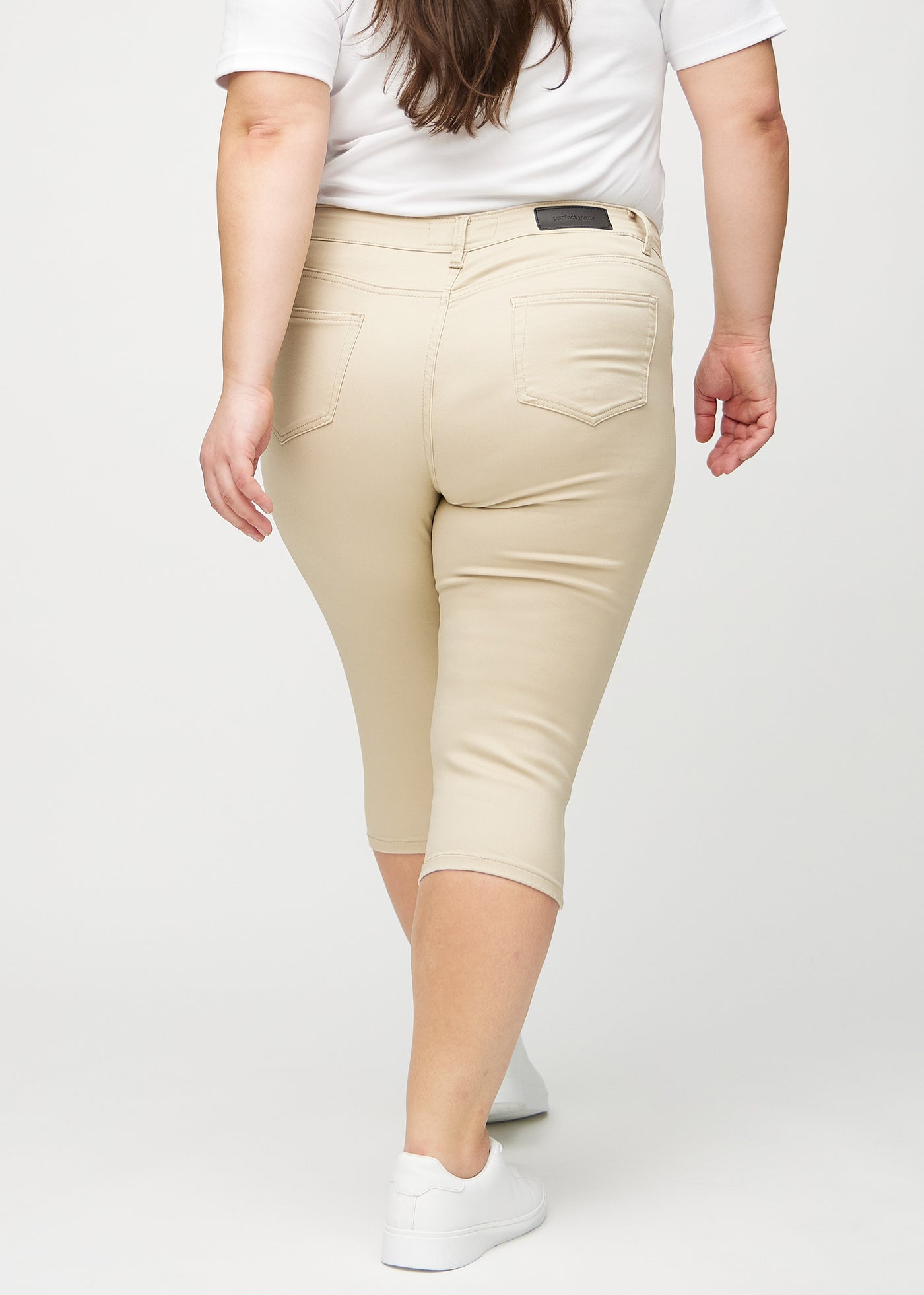 Beige skinny capris set bagfra på en plus-size model, så man kan se hele produktet.