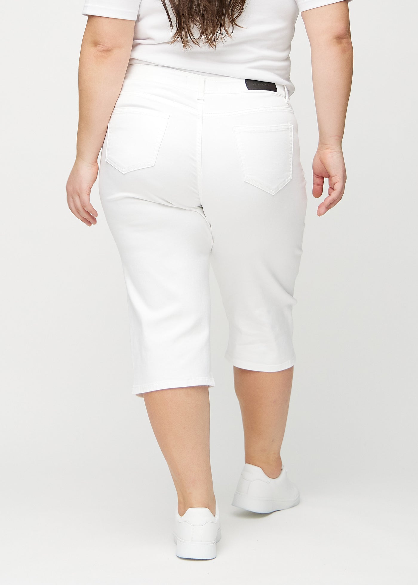 Hvide regular capris set bagfra på en plus-size model, så man kan se hele produktet.