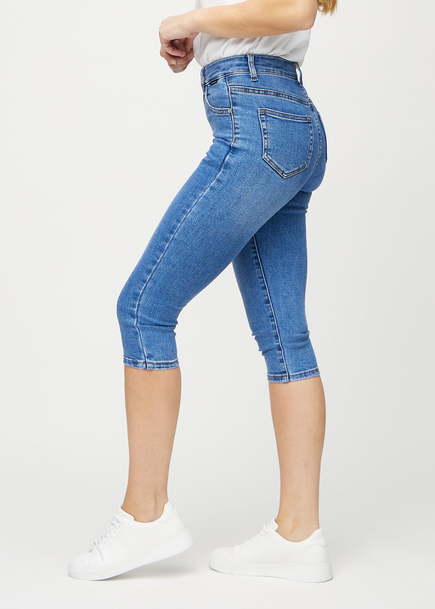 Denim skinny capris set fra siden på model.