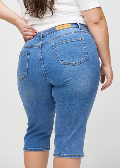 Denim regular capris set bagfra tæt på en plus-size model for at vise detaljer.