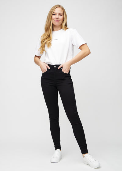 Fuldt billede af model i sorte skinny jeans.