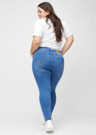 Denim skinny jeans set bagfra på en plus-size model, så man kan se hele produktet.