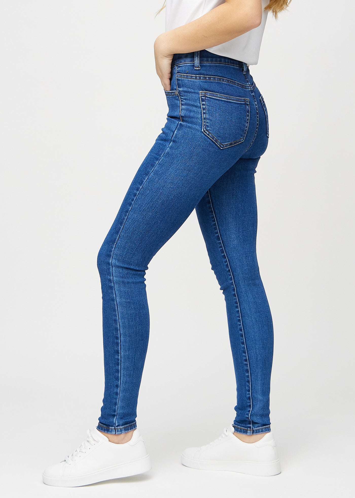 Mørk denim skinny jeans set fra siden på model.