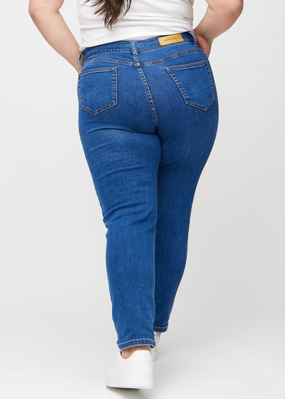 Mørk denim slim ultra high rise jeans set bagfra på en plus-size model, så man kan se hele produktet.