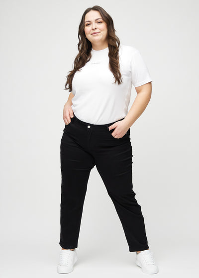 Fuldt billede af en plus-size model i sorte regular jeans.