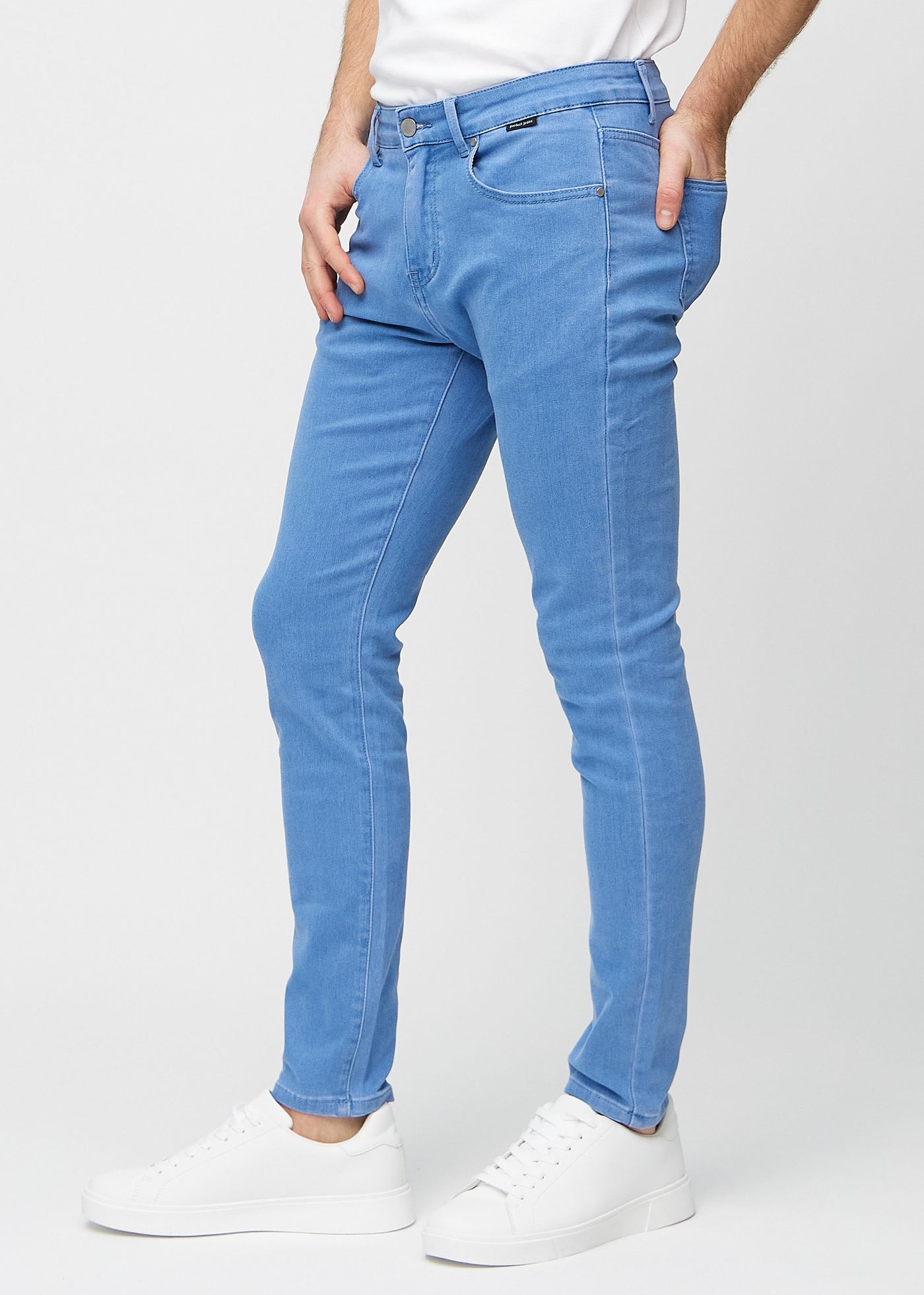 Blå slim jeans set fra siden på model.