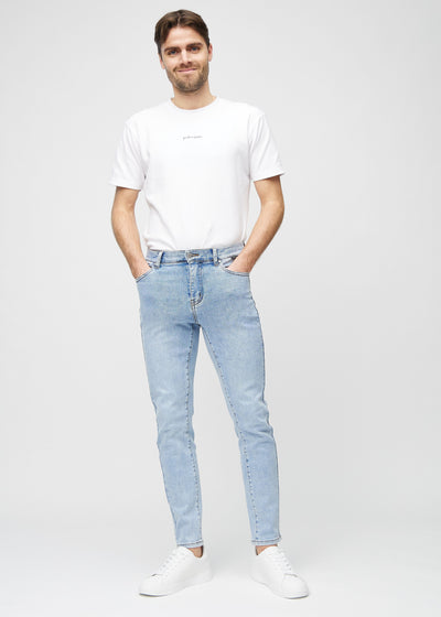 Fuldt billede af model i lys denim slim jeans.