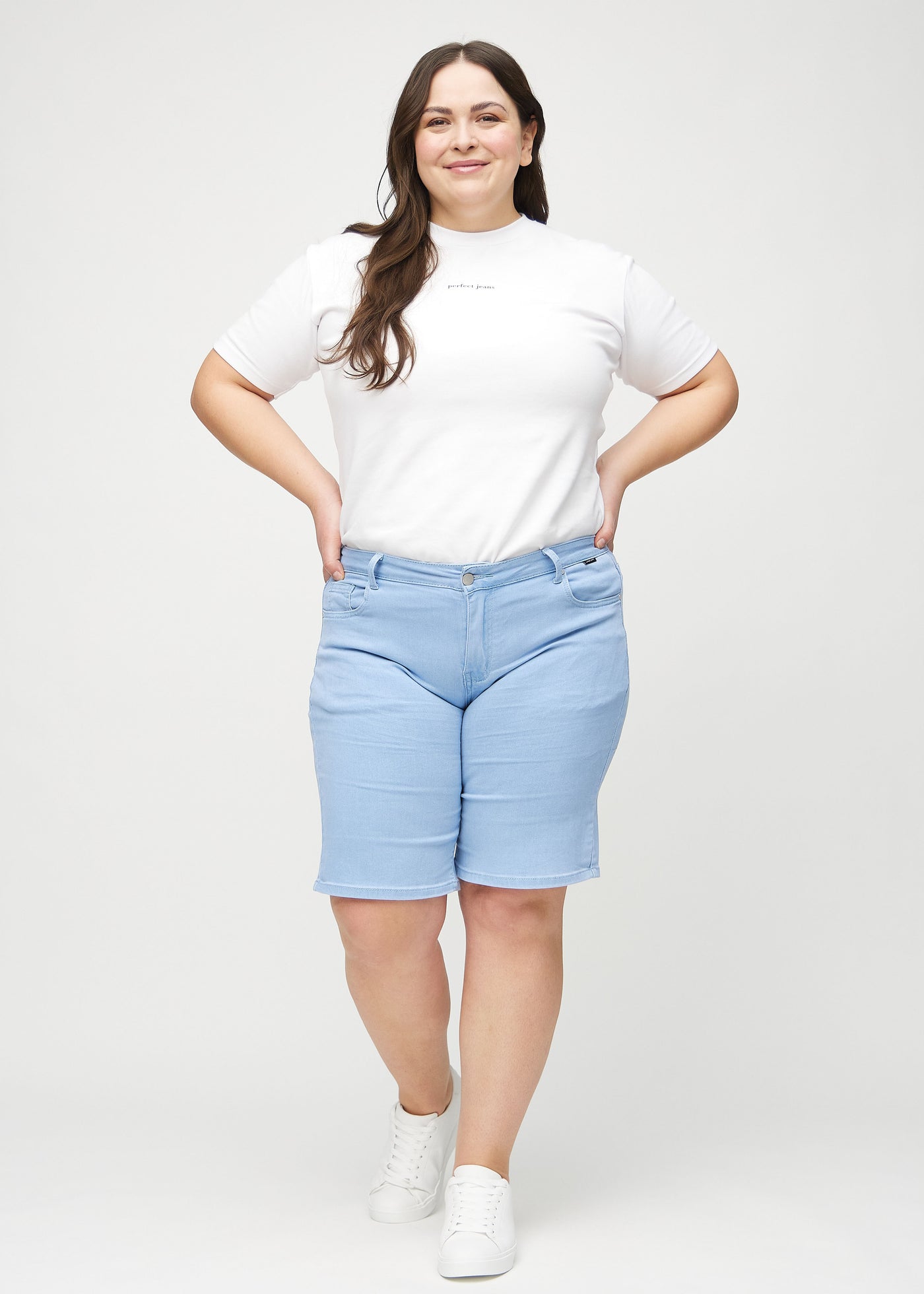 Plus-size model går ind i billedet, strækker i sine shorts, viser dem frem ved at dreje rundt, og forlader derefter billedet.