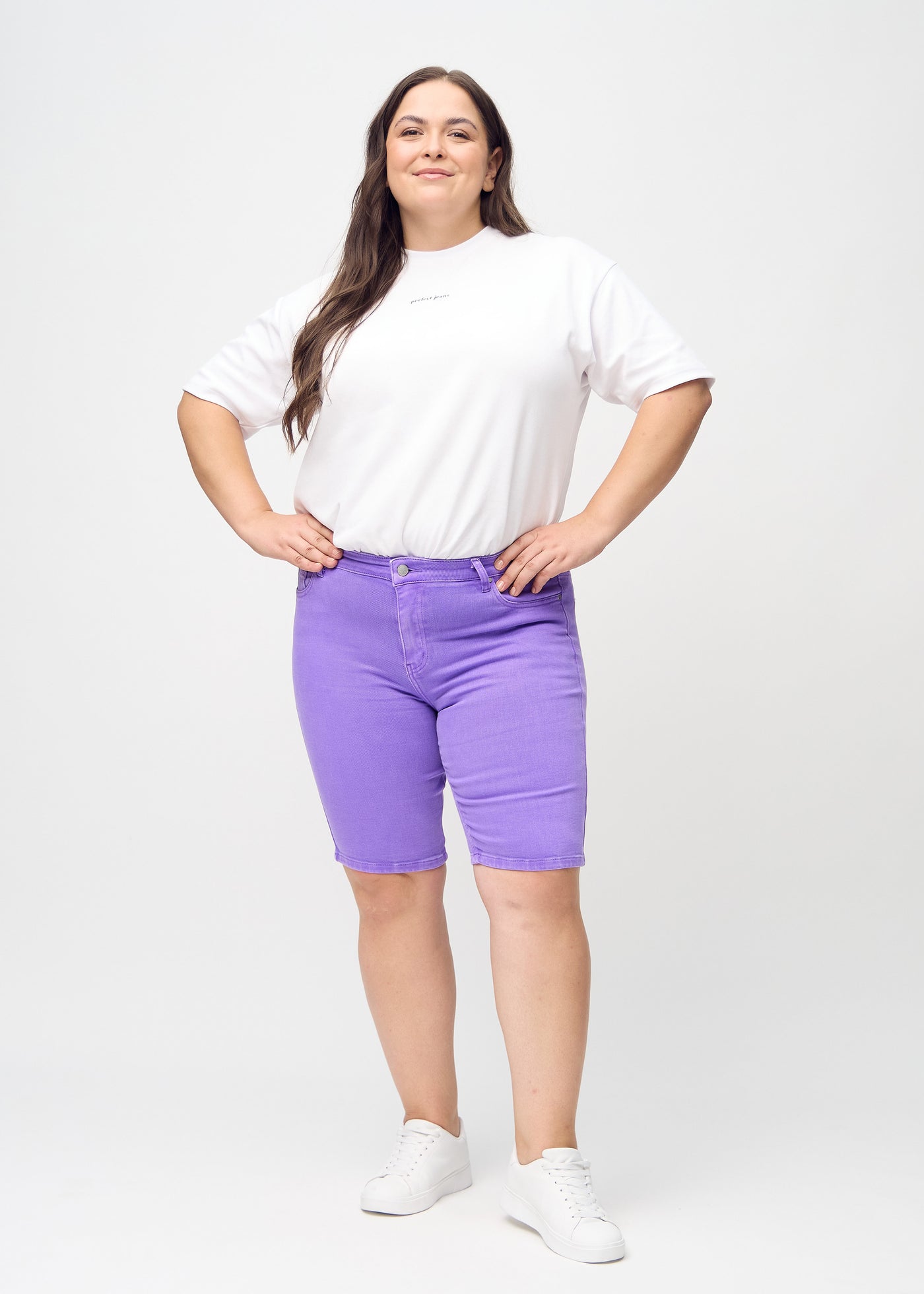 Plus-size model går ind i billedet, strækker i sine shorts, viser dem frem ved at dreje rundt, og forlader derefter billedet.