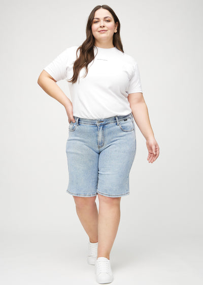 Plus-size model går ind i billedet, strækker i sine shorts, viser dem frem ved at dreje rundt, og forlader derefter billedet.