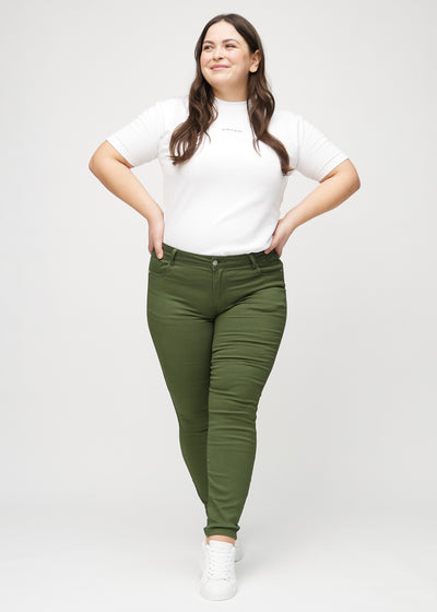 Plus-size model går ind i billedet, strækker i jeansene, viser dem frem ved at dreje rundt, og forlader derefter billedet.